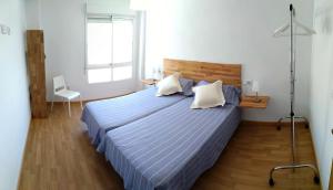 een slaapkamer met een groot bed en een blauw dekbed bij Apartamento Almirante Baldasano in Cartagena