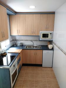 a kitchen with a sink and a microwave at Apartamento Almirante Baldasano in Cartagena