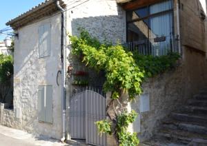 an old house with a gate and vines at Maison de charme pittoresque Villeneuve lez Avignon in Villeneuve-lès-Avignon