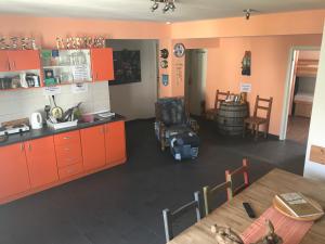 une cuisine avec des armoires orange et une table avec une chaise dans l'établissement Hostel Marina Trogir, à Trogir