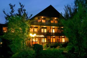 a large building with lights on in the night at Hotel an der Ilse in Lemgo