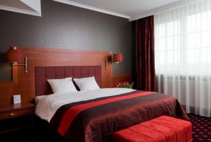 a bedroom with a large bed and a red bench at Hotel Panorama in Mszczonów