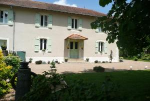 a large white house with a green door at Domaine Serrot in Saint-Élix-Theux