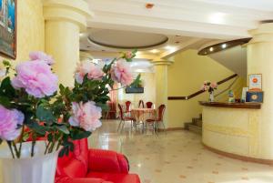 a lobby with a table and chairs and pink flowers at Sharm Hotel in Adler