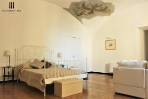 um quarto branco com uma cama e uma cadeira em Hotel Terme Neronensis em Pozzuoli