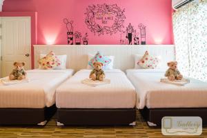 Dos camas con ositos de peluche sentados en una habitación en Gallery Lake View Hotel, en Khon Kaen