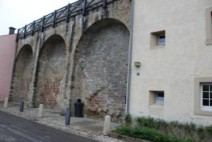 uma velha parede de tijolos com dois arcos num edifício em Turm Hämelmaous em Echternach