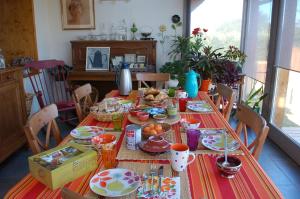 un lungo tavolo con cibo sopra in cucina di B&B La Maison Des Collines Autour Chambres d'hôtes a La Chapelle