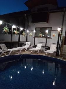 a swimming pool with lounge chairs and a table at Guest House Unika in Tryavna