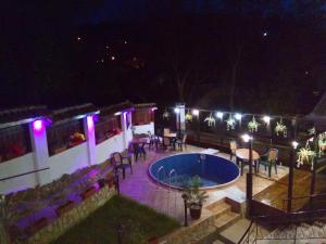 an outdoor patio with a swimming pool at night at Guest House Unika in Tryavna