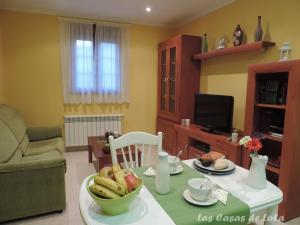a living room with a table with a bowl of fruit at Las Casas de Lola in Rabago