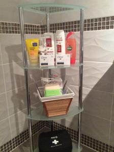 a shelf in a bathroom with products on it at Ty Erin in Llandeilo