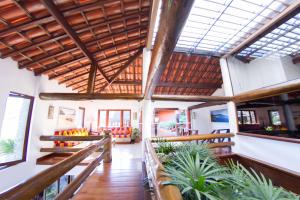 een grote kamer met houten plafonds en potplanten bij Azeda Boutique Hotel in Búzios