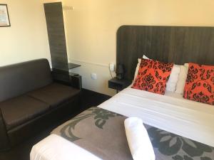 una camera con letto e divano di Businessburg Hotel a Johannesburg
