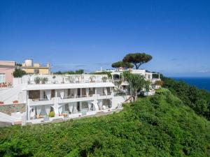 a large white building on a hill with the ocean at Paradise Relais Villa Janto' in Ischia