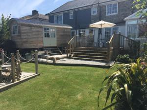 a backyard with a deck and a house at Downsfield Bed and Breakfast in St Ives