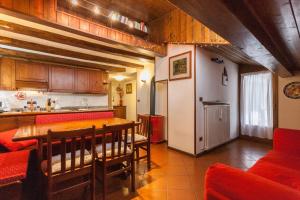 eine Küche und ein Esszimmer mit einem Tisch und Stühlen in der Unterkunft Casa Silva in Falcade