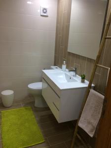 a bathroom with a sink and a toilet and a mirror at Outeiro House in Ponte de Lima
