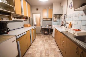 a kitchen with wooden cabinets and tile floors at Apartamenty Iława in Iława