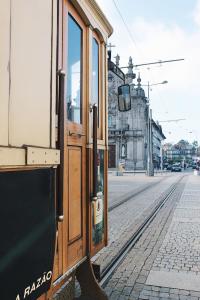 um trem nos trilhos em uma rua da cidade em Lost Apartments em Porto