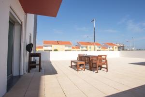 Un patio con una mesa y sillas en un tejado. en Just Sea, en Peniche