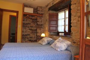 1 dormitorio con 1 cama en una pared de piedra en Apartamento La Vieja Panadería 1, en Vega de Pas