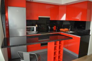 a kitchen with red cabinets and a black counter top at Atlantic Residence in Caminha