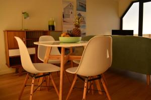a table and chairs with a bowl of pineapple on it at Atlantic Residence in Caminha