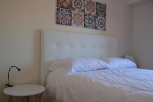 ein Schlafzimmer mit einem weißen Bett und einem Tisch in der Unterkunft Atlantic Residence in Caminha