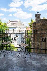 un patio con 2 mesas de picnic y una valla en 3 room apartment in the beautiful street en Budapest