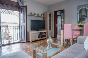 a living room with a tv and a table at El Pilar Home in Córdoba