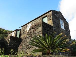 a stone building with a plant in front of it at Casa Adega Alto do Passinho in Terra Alta