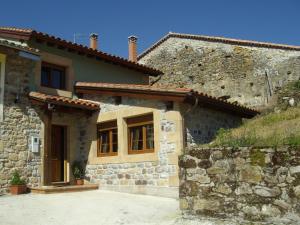 a stone house with a stone wall at Las Casas de Lola in Rabago