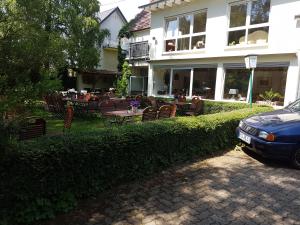 a car parked in front of a house with a table and chairs at Forellenhof-Waldhölzbach in Waldhölzbach