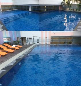 una gran piscina en un edificio con agua azul en Newport City Condo near Manila Airport Terminal 3, en Manila