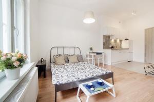 een woonkamer met een bed en een keuken bij Apartament w Centrum Olsztyna in Olsztyn