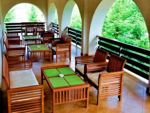 a restaurant with wooden chairs and tables and windows at Dom Hotel Domodedovo in Domodedovo