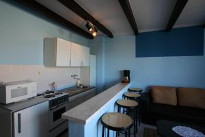 a kitchen with a counter and some stools in it at Apartments Silo in Šilo