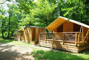 una cabina in legno nel bosco con alberi di Camping La Châtaigneraie a Gravières