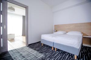 Postel nebo postele na pokoji v ubytování Apartamenty Villa Baltica Rewal - jacuzzi na dachu, wi-fi, parking w cenie + 26 fotografií