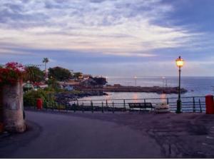 a street light sitting next to a beach with the ocean at Luxurious Street Apartments in Catania