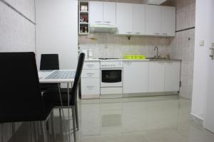 a kitchen with white appliances and a table with chairs at Apartman Maksimir Relax Zagreb-75m2 in Zagreb