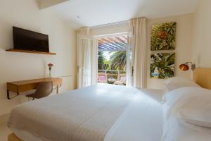 a bedroom with a bed and a desk and a window at Cape Standard Guest House in Cape Town