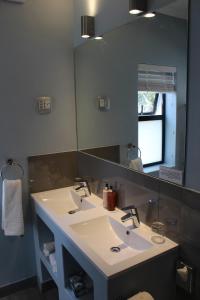 baño con 2 lavabos y espejo grande en Whale Rock Luxury Lodge en Hermanus