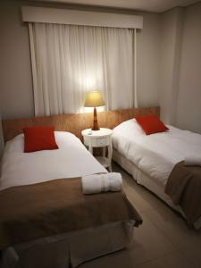 ein Schlafzimmer mit 2 Betten und einem Tisch mit einer Lampe in der Unterkunft Realty PY Villa Morra in Asunción