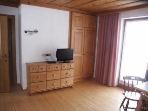 a room with a wooden dresser with a television on it at Ferienwohnungen Steidl in Innervillgraten