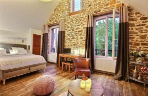 a bedroom with a bed and a stone wall at La Cotentine Maison d'Hôtes in Saint-Pair-sur-Mer +65 photos