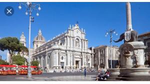 a large white building with a fountain in front of it at Luxurious Street Apartments in Catania