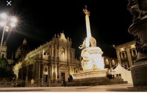 a large building with a statue in front of it at Luxurious Street Apartments in Catania