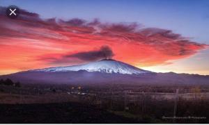 a erupting volcano with snow on top of it at Luxurious Street Apartments in Catania